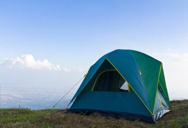 Tent on a grass and blue sky clipart