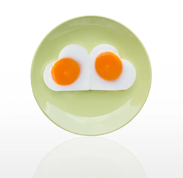 緑の皿に目玉焼き心 — ストック写真