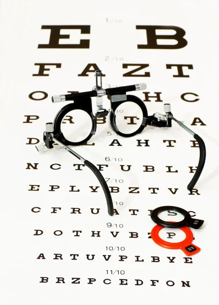 Glasses lying on optotype test — Stock Photo, Image