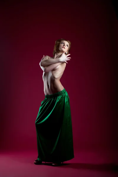 Schoonheid vrouw die zich voordeed op rode in groene jurk — Stockfoto