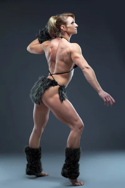 Tunga kropp builder kvinna i amazon päls klänning — Stockfoto