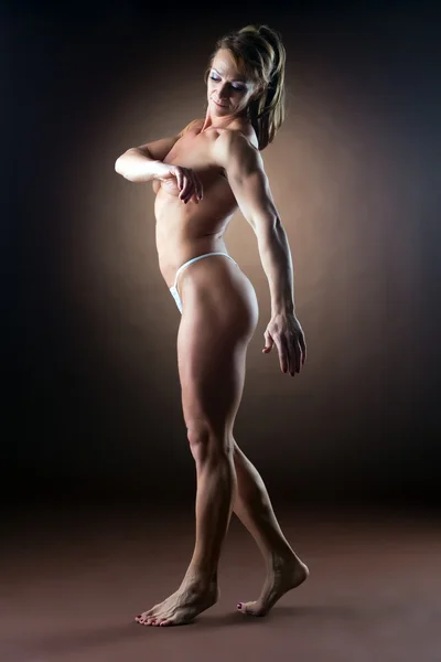 Stark kvinna body builder promenad sida — Stockfoto
