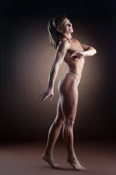 Stark kvinna body builder promenad sida — Stockfoto
