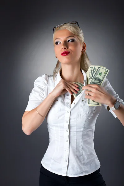 Jonge blonde vrouw verbergen geld onder shirt — Stockfoto