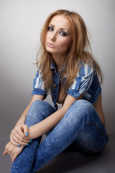 Beautiful girl sit in jeans and jacket — Stock Photo, Image