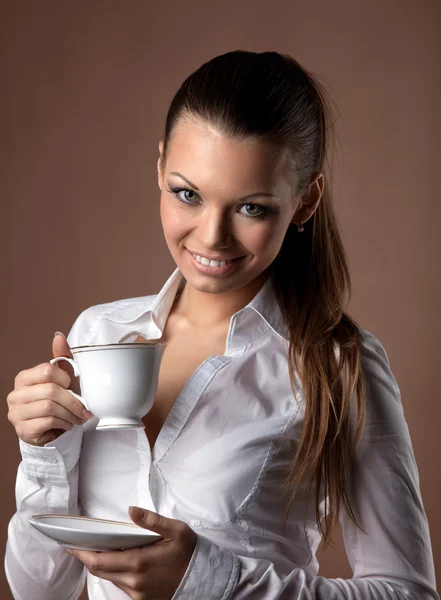 Счастливая женщина с чашкой кофе улыбается коричневому — стоковое фото