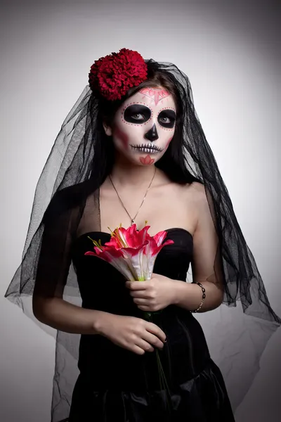 Femme sérieuse dans le crâne masque d'art du visage et des fleurs — Photo