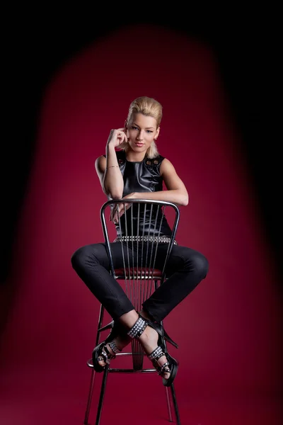Genç kadın oturup bar sandalyesi rock deri ceket — Stok fotoğraf