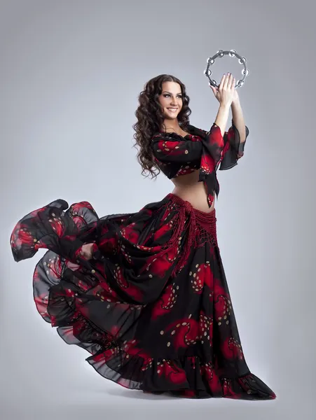 Молодая женщина танцует на цыганском с бубном — стоковое фото