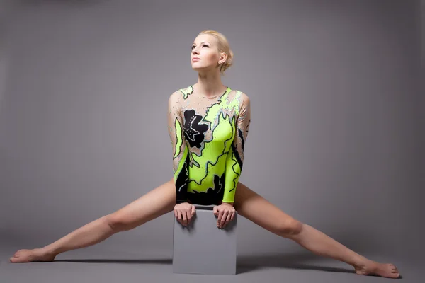 Roztomilý profesionální gymnastkou dělá rozdělení na krychli — Stock fotografie