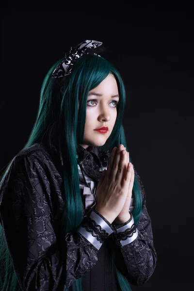 Девушка косплее персонаж аниме молиться в темноте — стоковое фото