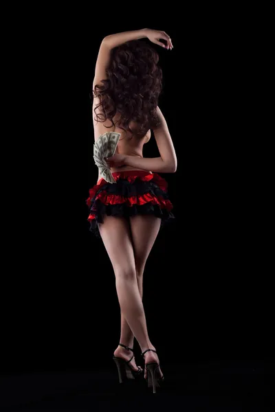 Striptýz dívka v červené tanec s penězi ve tmě — Stock fotografie