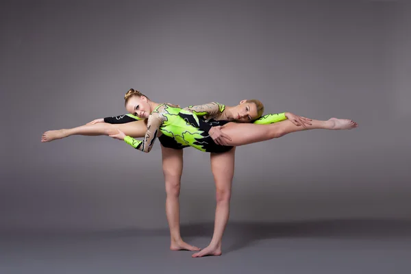 Zwei junge Frauen als Akrobaten üben Paarprogramm — Stockfoto