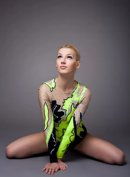 Gri poz jimnastikçi elbiseli genç kadın — Stok fotoğraf