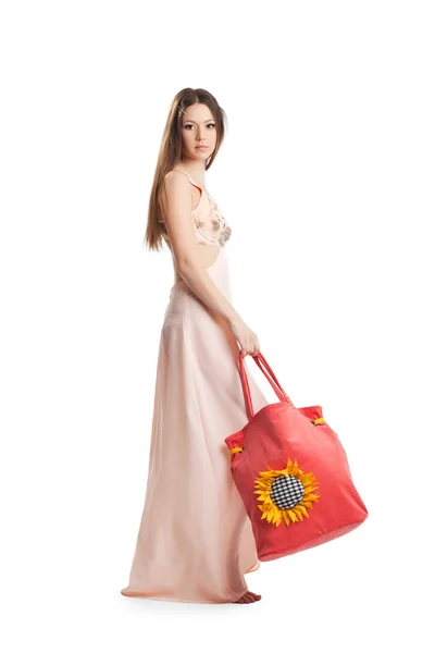 Güzellik kız yürümek gül elbise ve kırmızı plaj çantası — Stok fotoğraf