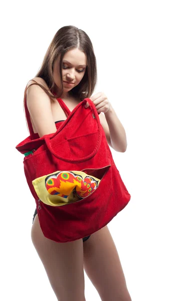 Mulher toalha de busca em saco de praia vermelho isolado — Fotografia de Stock