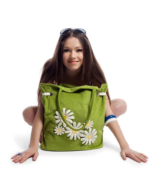 Yong mulher sentar com saco de praia verde sorriso isolado — Fotografia de Stock