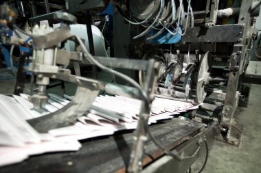 Ready newspaper on production line clipart