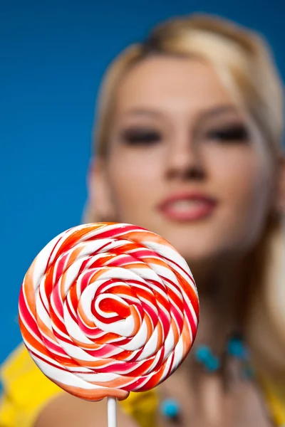 Big lollipop and blond woman at background — Stock Photo, Image