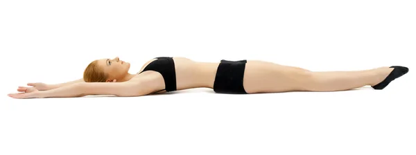 Йонг женщина в черном расслабленной лежал на белом — стоковое фото