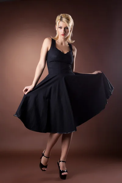 Cute woman in black pinup style dance on dark — Stock Photo, Image