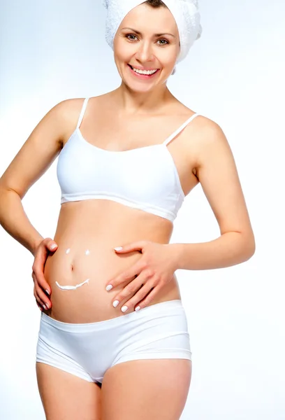 Embarazada joven mujer con crema cosmética — Foto de Stock