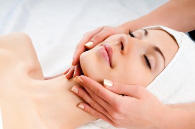 Woman receiving facial massage clipart