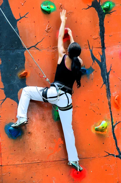 Meisje klimmen op een klimmuur — Stockfoto