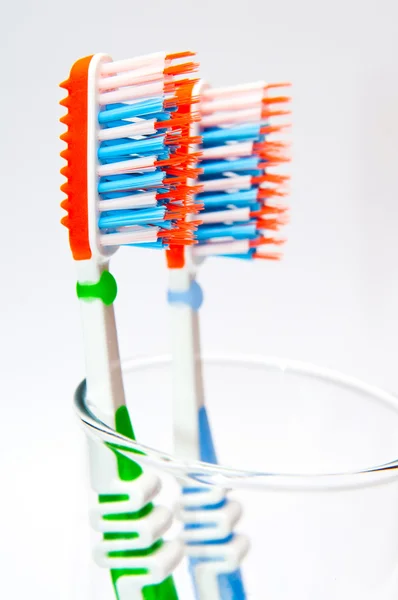 Two toothbrushes in a glass beaker — Stock Photo, Image