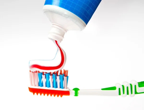 Зубная паста прижимается к зубной щетке — стоковое фото