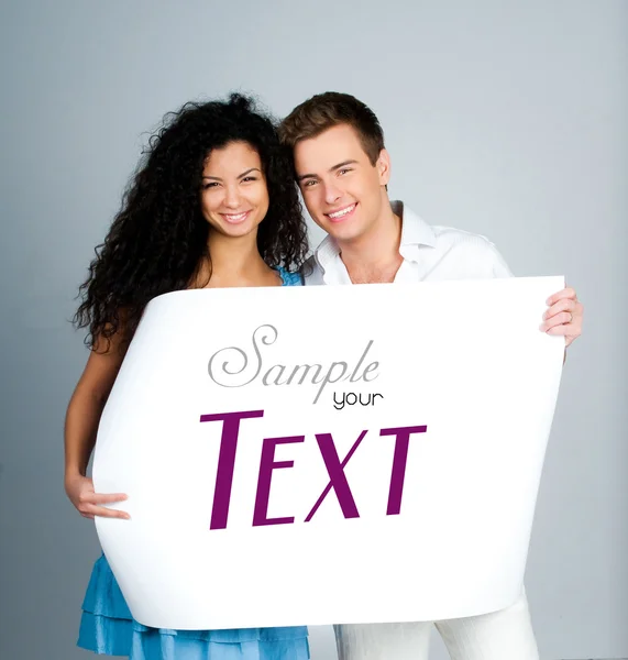 Couple tenant un papier avec un exemple de texte — Photo