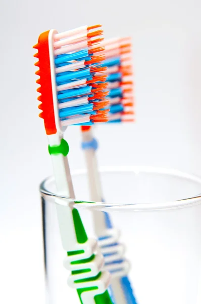 Two toothbrushes in a glass beaker — Stock Photo, Image