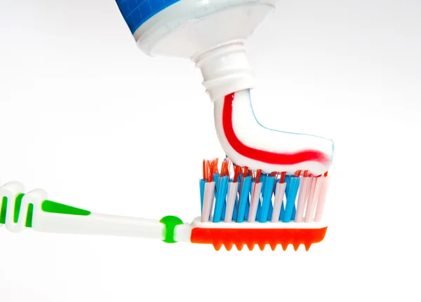 Toothpaste being squeezed onto toothbrush — Stock Photo, Image
