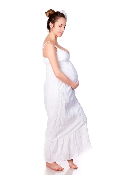 Беременная женщина в белом платье — стоковое фото