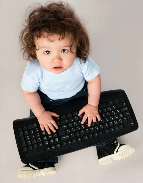 Petit enfant avec un clavier d'ordinateur — Photo