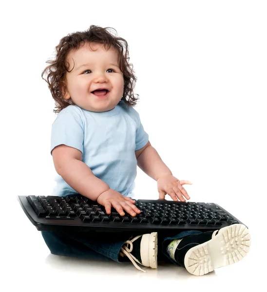 Liten unge med en dator tangentbord — Stockfoto