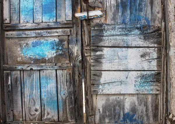 青い絵の具で古い腐ったドア — ストック写真