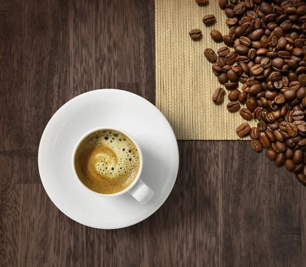 Чашка кофе и бобы на мешковине — стоковое фото