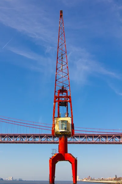 Red crane and red metallic bridge on background — Stock Photo, Image