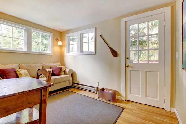 Quarto com sofá, porta e escrivaninha em cores naturais . — Fotografia de Stock