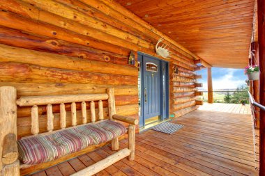 Wood log cabinet porch with entrance and bench. clipart