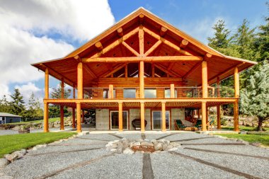 Large log cabin with porch and fire circle. clipart