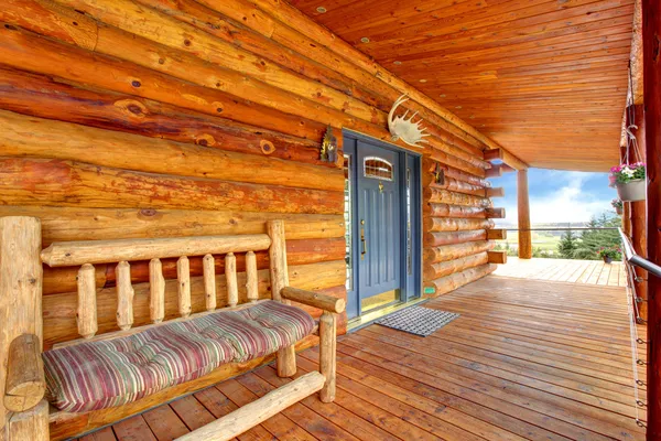 Крыльцо деревянного бревенчатого шкафа со входом и скамейкой . — стоковое фото