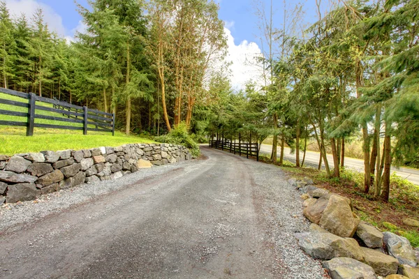 stock image Horse farm rural road with fence.