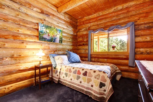 Blokhut rustieke slaapkamer met blauwe gordijnen. — Stockfoto