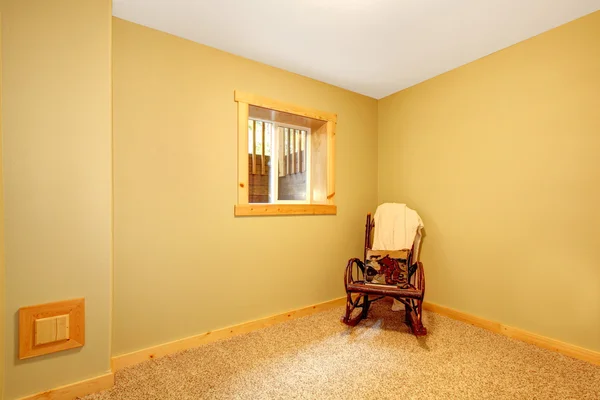 Einfaches leeres Kellerschlafzimmer mit Stuhl. — Stockfoto