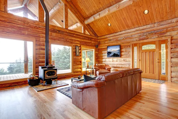 Salón de lujo con cabaña de madera y sofá de cuero . — Foto de Stock