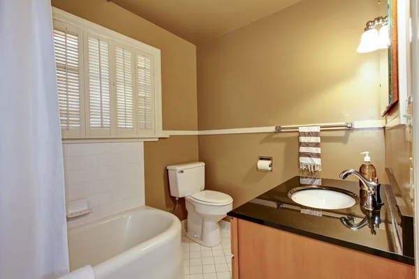 Old brown bathroom with white tub. — Stock Photo, Image