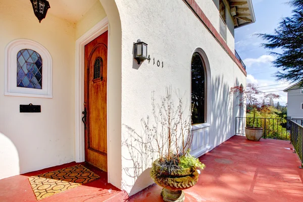 Casa bianca in stile spagnolo con portico rosso e porta d'ingresso . — Foto Stock