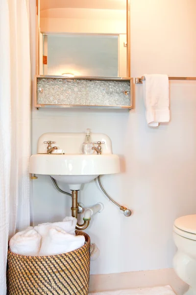 Mała niebieska łazienka z umywalką antyczne i białe ręczniki. — Zdjęcie stockowe